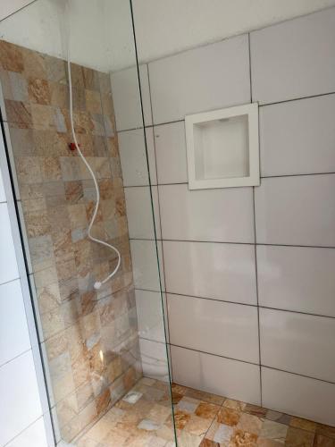 a shower with a glass door in a bathroom at Microcasa 1 - Centro Maricá in Maricá