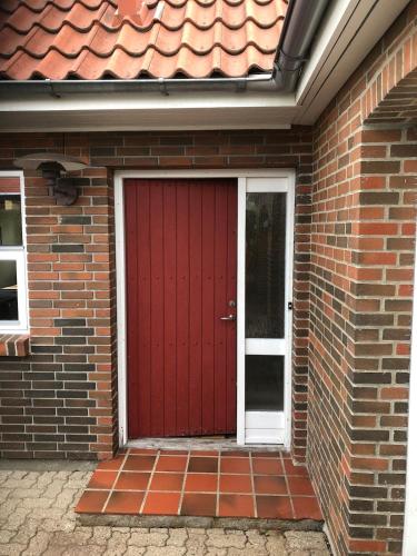 a red door on a brick house with at Horsens, Vejle, Aarhus, Fredericia in Løsning