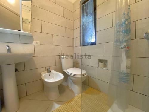 ein weißes Badezimmer mit Toilette und Waschbecken in der Unterkunft Ferienunterkunft in Costa Rei in Costa Rei