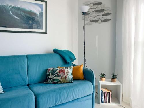 - un canapé bleu dans le salon avec une lampe dans l'établissement Risso - charming one bedroom with a balcony, à Nice