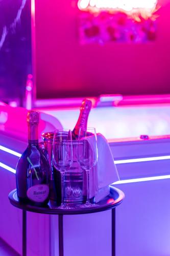 - une table avec deux bouteilles et des verres dans l'établissement Toulouse Love room, suite avec spa privatif, à Toulouse