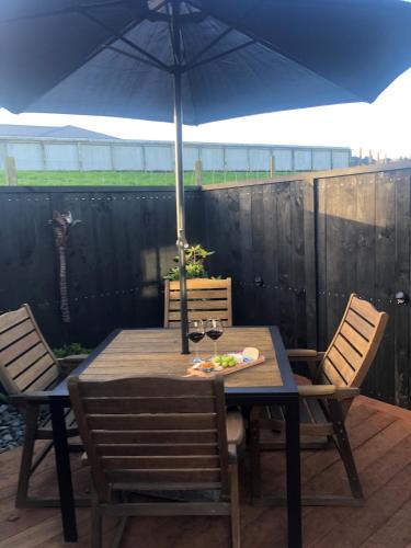 a table and chairs with an umbrella on a patio at Hamurana Roost in Rotorua