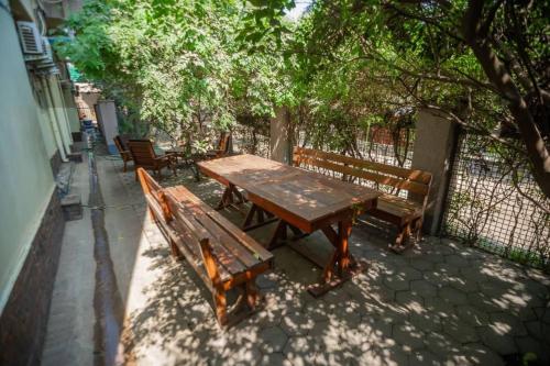 a wooden picnic table and benches on a sidewalk at A Charming Bed And Breakfast In Lubumbashi in Lubumbashi
