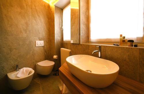 a bathroom with a sink and a toilet at Da Gigi Alpine Rooms in Crandola Valsassina