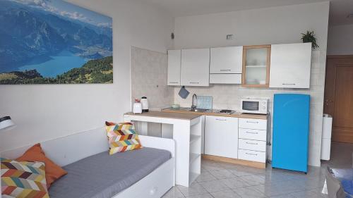 リーヴァ・デル・ガルダにあるGardaSunrise Apartment - Riva del Gardaのキッチン(白いキャビネット、青い冷蔵庫付)