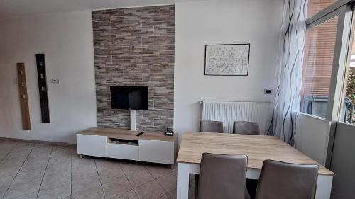 リーヴァ・デル・ガルダにあるGardaSunrise Apartment - Riva del Gardaのテーブルとテレビのあるダイニングルーム