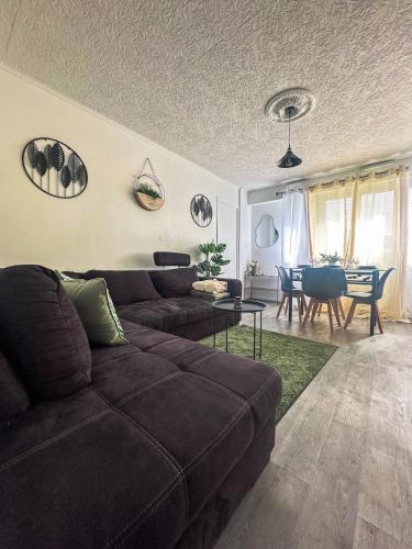 un salon avec un canapé marron et une table dans l'établissement Ma Parenthèse Confortable à deux pas de Paris, à Épinay-sur-Seine