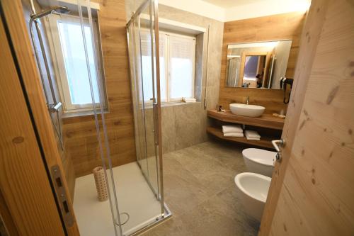 a bathroom with a shower and a toilet and a sink at Da Gigi Alpine Rooms in Crandola Valsassina