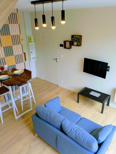 un salon avec un canapé bleu et une table dans l'établissement Appt Centre ville 2 pers Ty Basroz, au Guilvinec