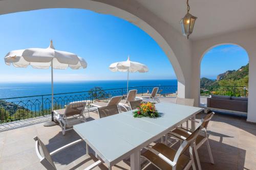 a dining room with a table and chairs and the ocean at Villa Marianna in Massa Lubrense