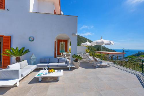 a patio with couches and an umbrella on a building at Villa Marianna in Massa Lubrense