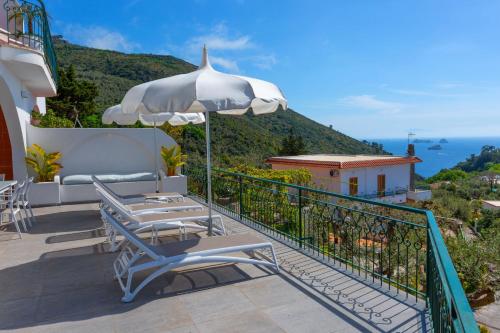 a balcony with two chairs and an umbrella at Villa Marianna in Massa Lubrense