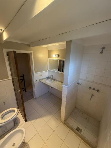 ein großes Badezimmer mit Toilette und Waschbecken in der Unterkunft Los Alerces in Villa Urquiza