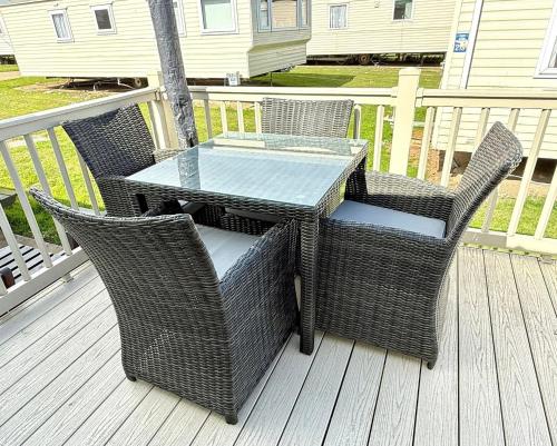 an outdoor table and chairs on a deck at 3 Bedroom 8 birth Caravan - Sand Le Mere in Tunstall