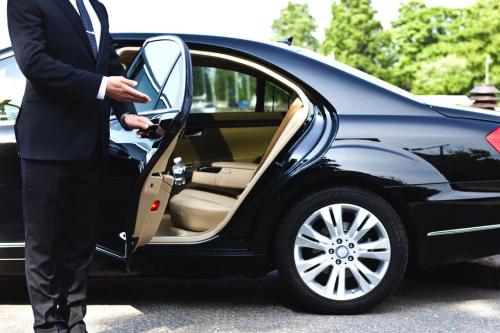 a man in a suit getting into a car at Beach&Golf suites in El Bedito