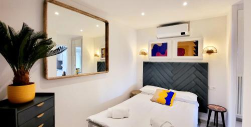 a bedroom with a white bed and a mirror at Tropical Art Apartment in Bissone