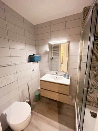 a bathroom with a toilet and a sink at Tropical Art Apartment in Bissone