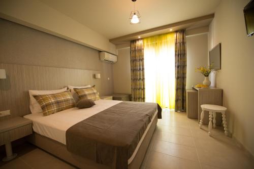 a bedroom with a large bed and a window at Aloe Apartments Ammouliani in Ammouliani