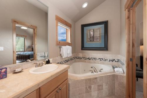 a bathroom with a tub and a sink and a mirror at Lakota Lookout private hot tub in Winter Park