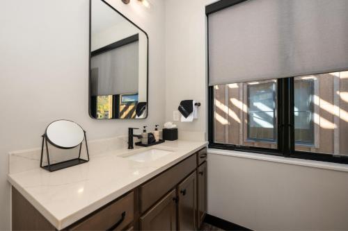 Un baño con lavabo y dos ventanas. en Experience luxury and adventure at Row 41 nestled in the heart of Winter Park Colorado, en Winter Park