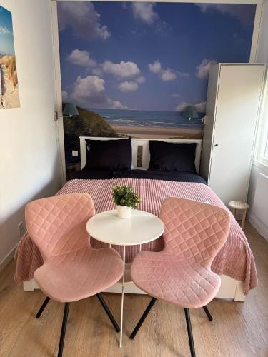 a bedroom with a bed with a table and two chairs at B&B de Zandtaart in Egmond aan Zee