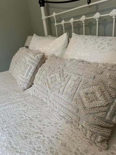 a white bed with two pillows and a blanket at Elm Barn in Diss