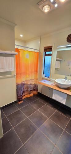 a bathroom with a sink and a mirror at The Rocks Chalets in Takaka