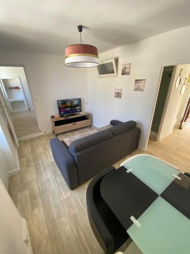 a living room with a couch and a glass table at Le coin détente in Nevers