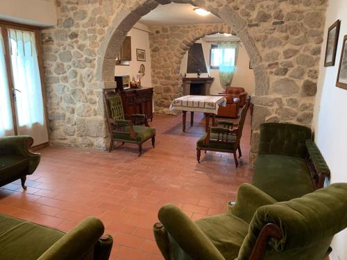ein Wohnzimmer mit grünen Möbeln und einer Steinmauer in der Unterkunft Podere Piccini with pool in Val d'Orcia-Tuscany in Piancastagnaio
