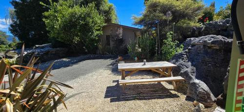 a wooden bench sitting in the middle of a garden at The Rocks Chalets in Takaka