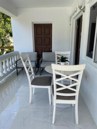 two white chairs and a table on a porch at Serene Getaway-Newly renovated spacious 2 beds 2 baths in Montego Bay