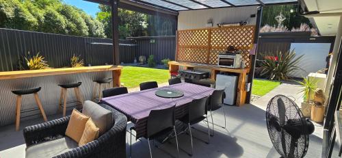 a patio with a table and chairs in a backyard at The Rocks Chalets in Takaka