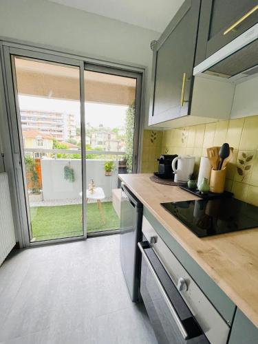 une cuisine avec un comptoir et une grande fenêtre dans l'établissement Charming green studio, au Cannet