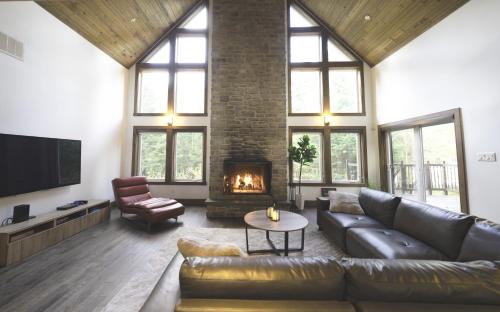 a living room with a couch and a fireplace at Luxury with hot tub 300mbps Wifi Games & more ! in Saint Adolphe D'Howard