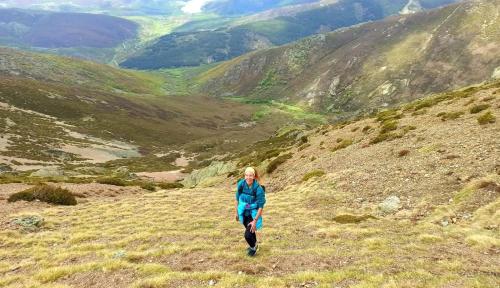 a woman running on a hill in the mountains at Hotel Pico Espiguete in Alba de los Cardaños