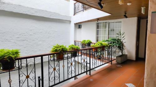 a balcony of a building with potted plants at Casa del Hidalgo Hotel Cali Centenario in Cali