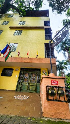 a yellow building with a sign in front of it at Casa del Hidalgo Hotel Cali Centenario in Cali