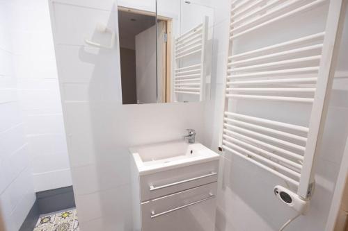 une salle de bain blanche avec un lavabo et un miroir dans l'établissement Albatros du Portel, à Le Portel