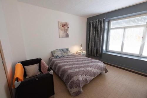 une chambre avec un lit, une fenêtre et une chaise dans l'établissement Albatros du Portel, à Le Portel