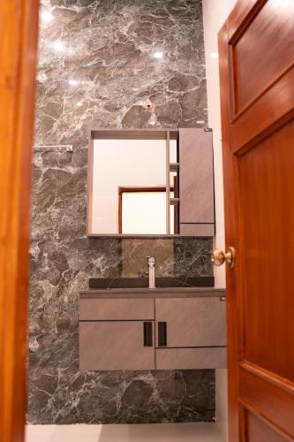 a bathroom with a sink and a mirror at Ariston Suites in Islamabad