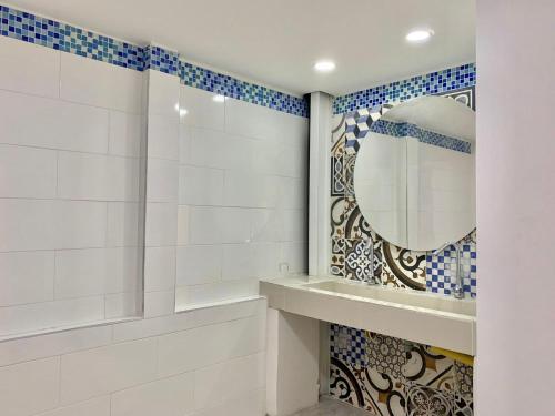 a bathroom with a mirror and blue and white tiles at CasaColibri in Pasto