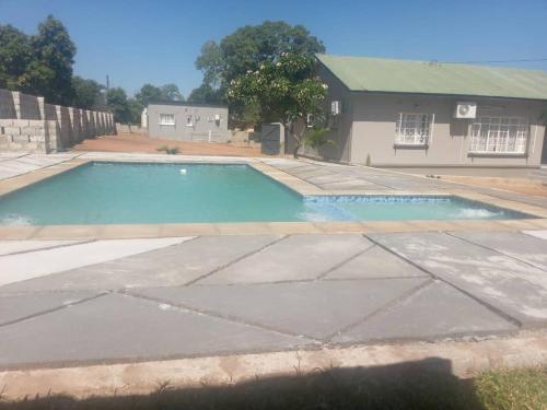 una piscina vacía frente a una casa en Yeta apartments, en Livingstone