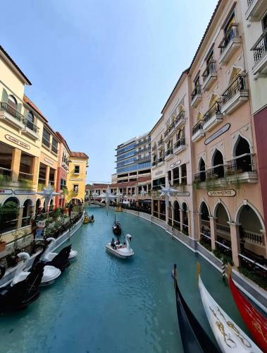 a group of boats in a canal between buildings at Mysuites20i in Sampong