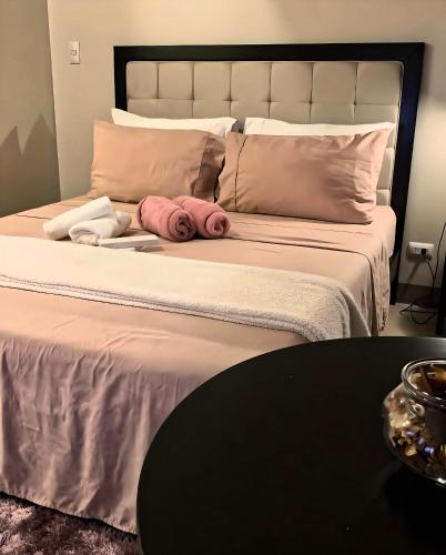 a large bed with pink pillows and a black table at Mysuites20i in Sampong