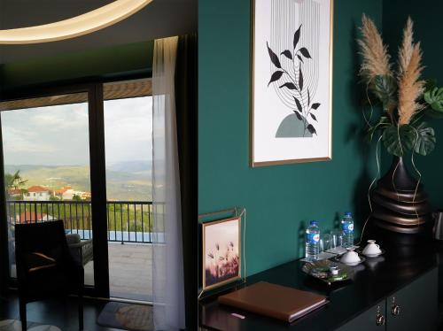 a room with a table with a vase on it at Quinta de Raj - Your Douro Valley Retreat in Peso da Régua