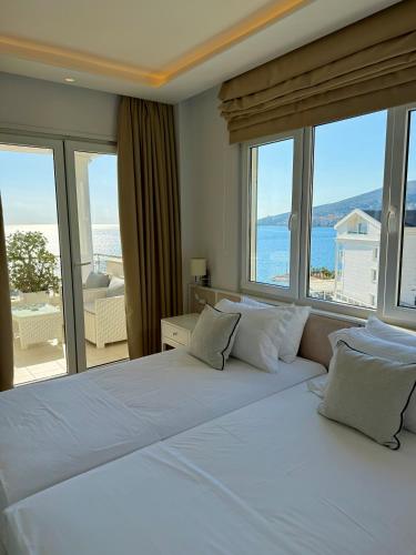 a bedroom with two beds and a view of the ocean at Limani Deluxe Apartments in Sarandë