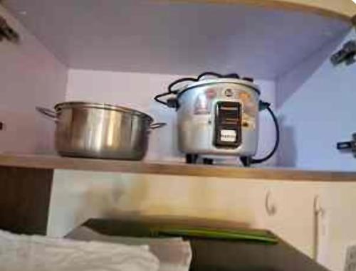 two pots and pans sitting on a shelf in a kitchen at Mysuites20i in Sampong