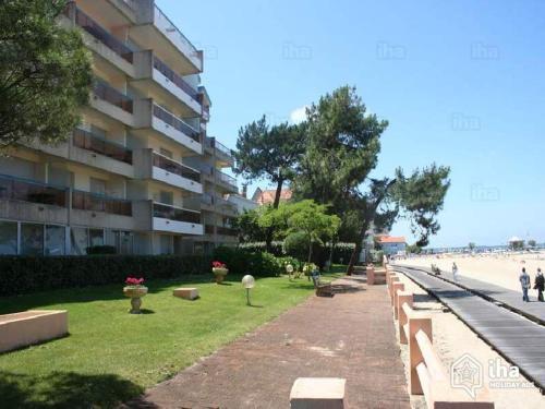 une rangée de bancs devant un bâtiment à côté de la plage dans l'établissement les pieds dans l'eau, à Arcachon