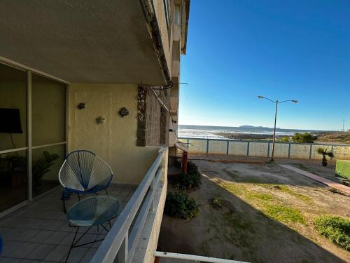 a porch with a chair and a view of the ocean at Beachfront Condo w Balcony & Parking in Rosarito Beach