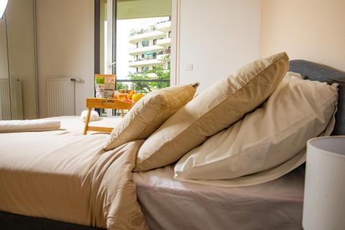 un lit avec quatre oreillers dessus dans l'établissement Le Tout élégant, à Colombes